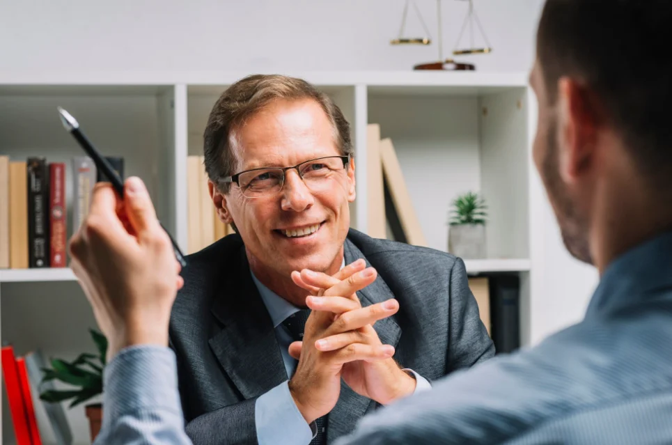 portrait of mature happy lawyer sitting with client